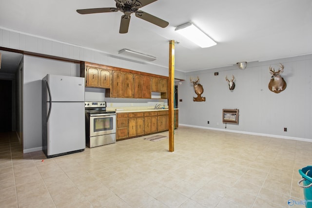 kitchen with electric stove, ceiling fan, white fridge, sink, and heating unit