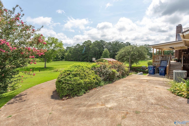 view of yard with central AC and ceiling fan