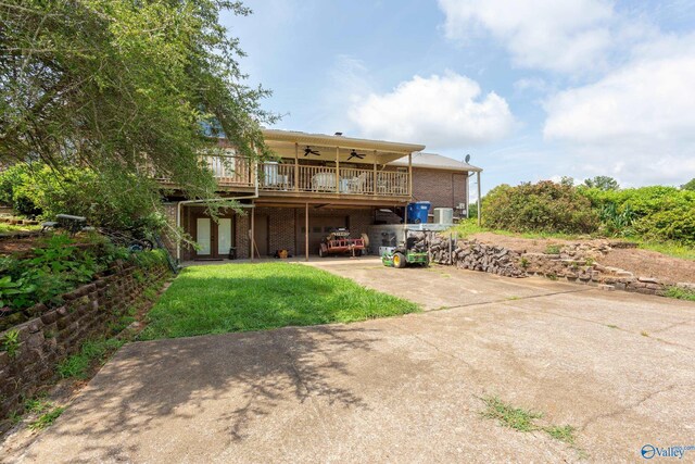 back of house featuring a lawn, ceiling fan, and a deck