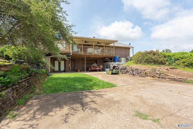 back of property with a deck, central air condition unit, a lawn, and ceiling fan