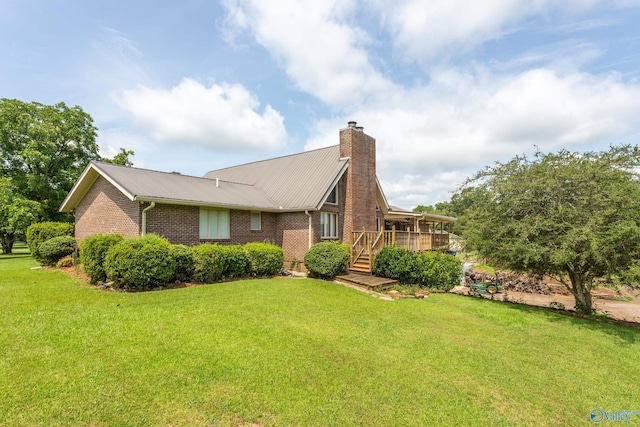 view of side of home featuring a yard and a deck