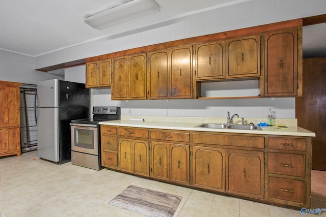 kitchen with sink, ornamental molding, and stainless steel appliances