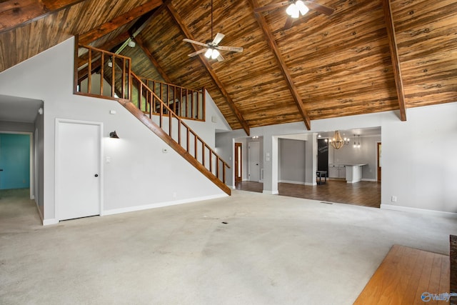 unfurnished living room featuring ceiling fan with notable chandelier, carpet, beamed ceiling, and wood ceiling