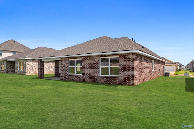 rear view of house with a lawn and central air condition unit