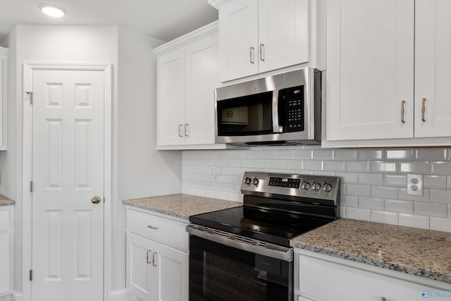 kitchen with tasteful backsplash, light stone counters, stainless steel appliances, and white cabinets