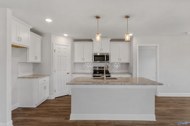 kitchen featuring white cabinetry, appliances with stainless steel finishes, and a kitchen island with sink