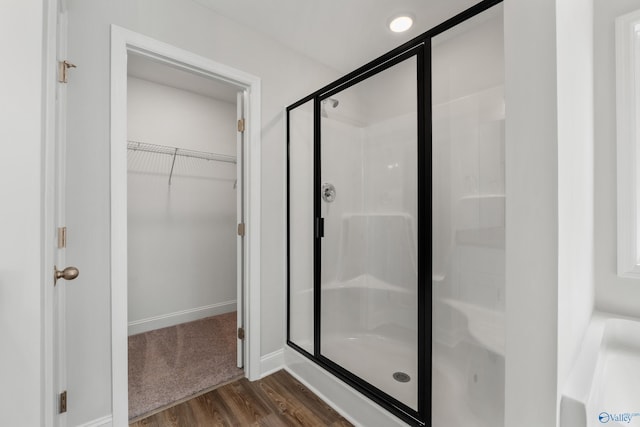 bathroom featuring a shower with door and hardwood / wood-style floors