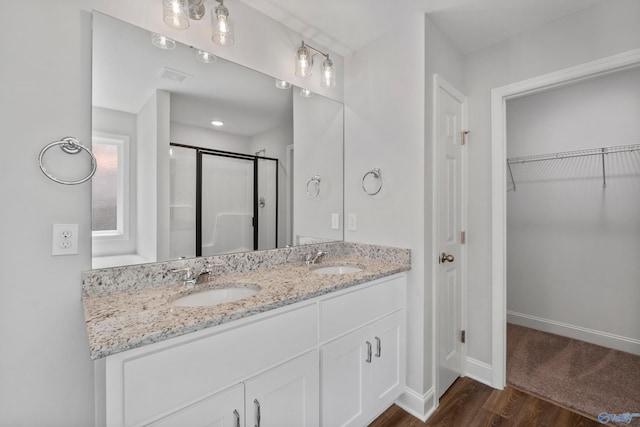 bathroom with vanity, wood-type flooring, and an enclosed shower