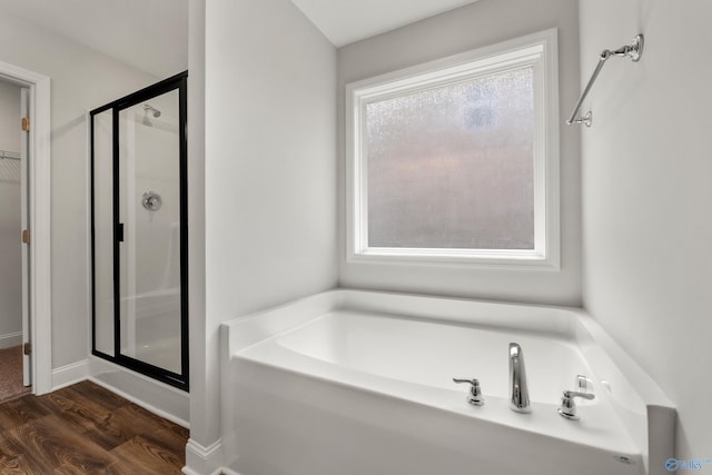 bathroom with hardwood / wood-style floors and independent shower and bath