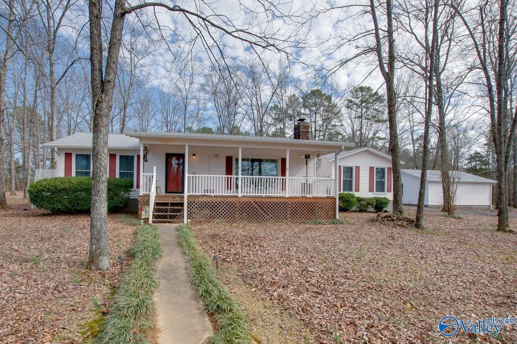 ranch-style house with a garage, an outdoor structure, and a porch