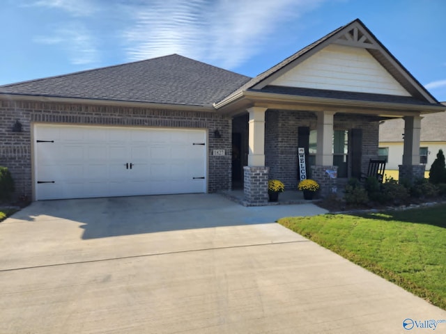 view of front of home with covered porch, a garage, and a front yard