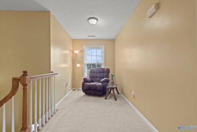 sitting room with carpet floors and a textured ceiling