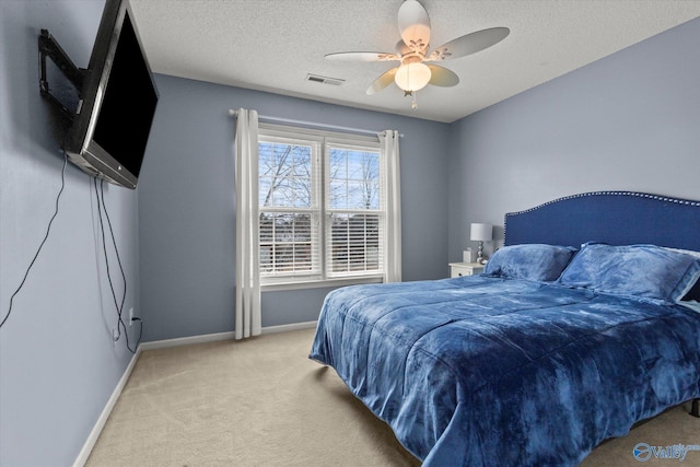 carpeted bedroom with ceiling fan and a textured ceiling