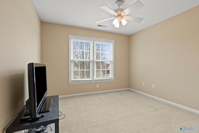 carpeted office with a textured ceiling and ceiling fan