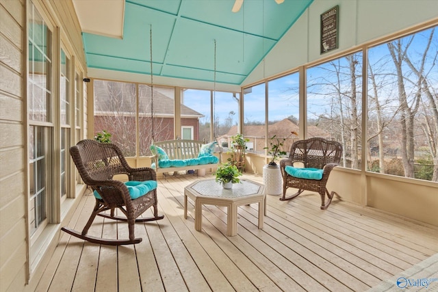 sunroom with plenty of natural light, lofted ceiling, and ceiling fan