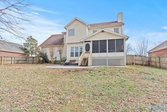 rear view of property featuring a patio area, a sunroom, and a lawn