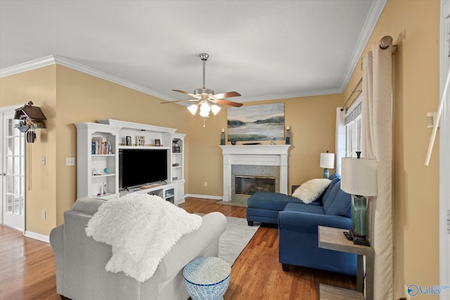 living room featuring wood-type flooring, crown molding, and a high end fireplace