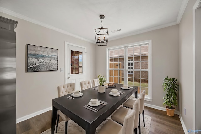 1417 Smith Ave SW, Decatur, AL 35603 - dining room featuring a chandelier, baseboards, dark wood-type flooring, and crown molding