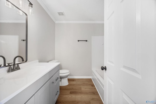 1417 Smith Ave SW, Decatur, AL 35603 - bathroom featuring crown molding, vanity, toilet, wood finished floors, and baseboards