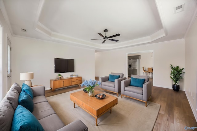 1417 Smith Ave SW, Decatur, AL 35603 - living area featuring a tray ceiling, a ceiling fan, wood finished floors, crown molding, and baseboards