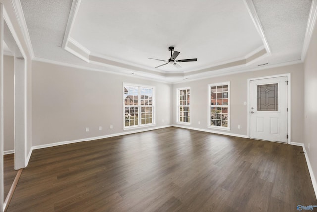 1417 Smith Ave SW, Decatur, AL 35603 - unfurnished living room featuring a tray ceiling, ceiling fan, ornamental molding, dark wood-type flooring, and baseboards