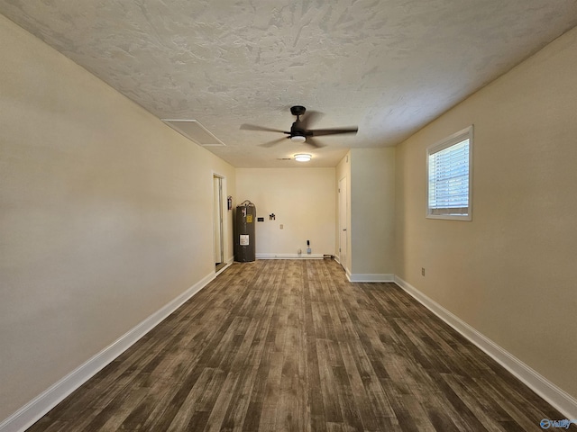 unfurnished room featuring ceiling fan, dark hardwood / wood-style flooring, electric water heater, and a textured ceiling