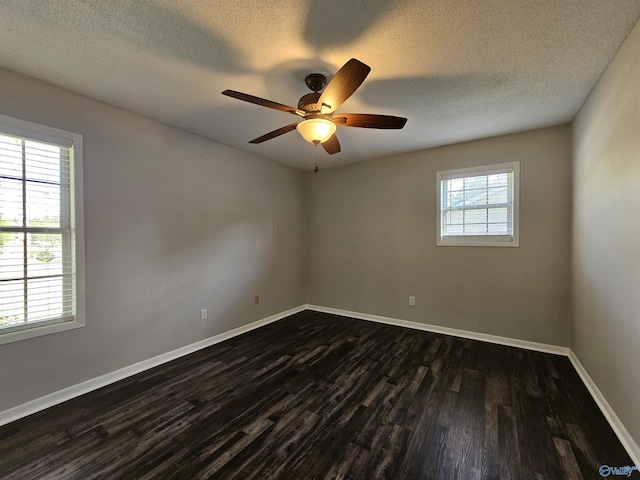 spare room with ceiling fan, a healthy amount of sunlight, dark hardwood / wood-style flooring, and a textured ceiling