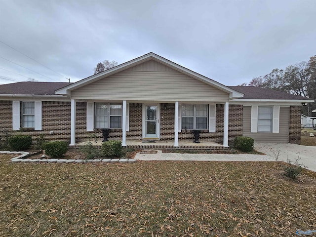 ranch-style home with covered porch and a front yard