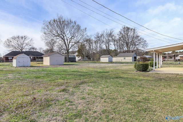 view of yard featuring an outbuilding, a storage shed, and fence