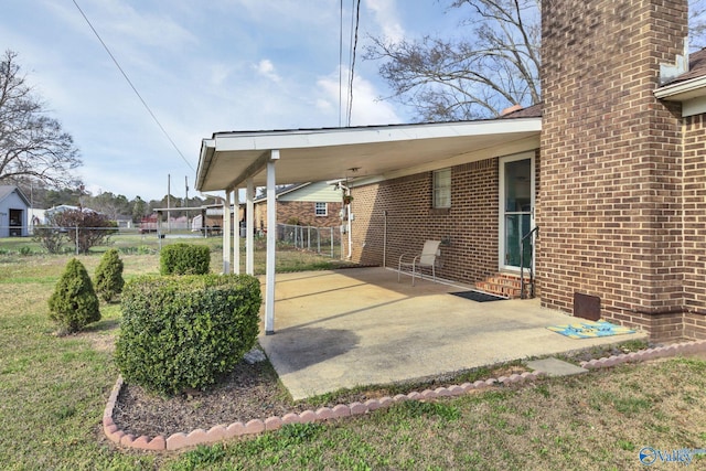 view of patio / terrace featuring entry steps, an attached carport, fence, and driveway