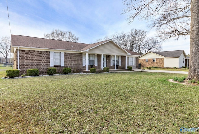 ranch-style home featuring brick siding and a front lawn