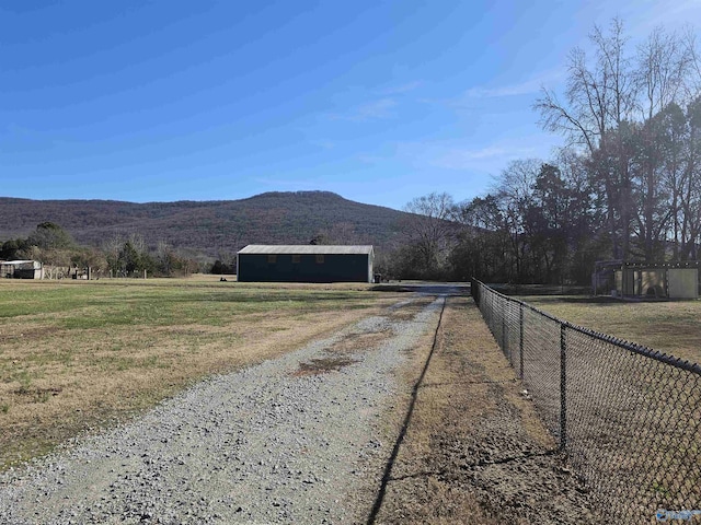 view of dirt / gravel driveway with a mountain view and a rural view
