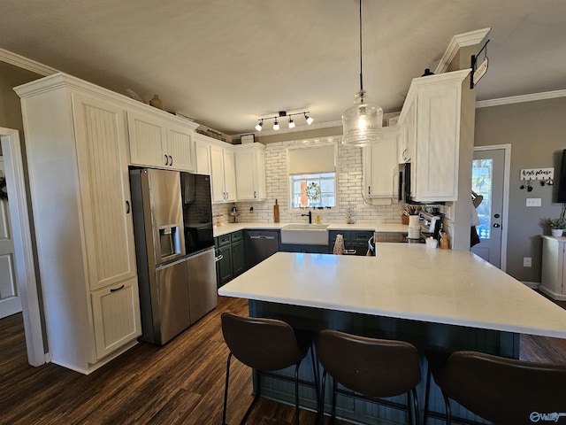 kitchen with stainless steel appliances, crown molding, a peninsula, dark wood-style flooring, and a kitchen breakfast bar