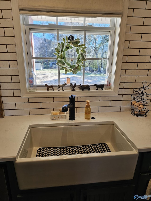 kitchen view of a sink, light countertops, and decorative backsplash