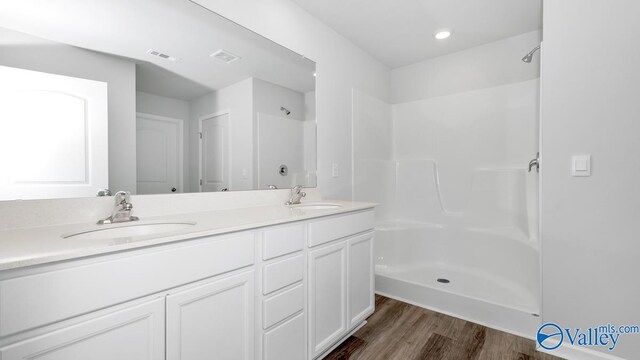 bathroom with a shower, vanity, and hardwood / wood-style flooring