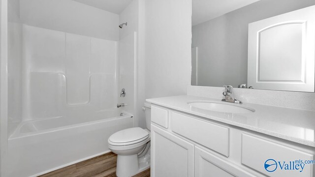 full bathroom with wood-type flooring, vanity, shower / bath combination, and toilet