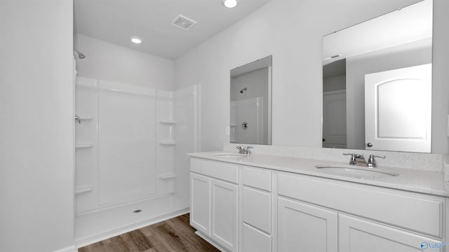 bathroom with vanity, wood-type flooring, and walk in shower