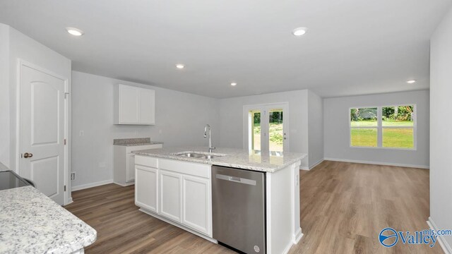 kitchen with white cabinets, a center island with sink, stainless steel dishwasher, and sink