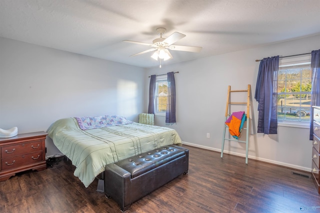 bedroom with a textured ceiling, dark wood-type flooring, and ceiling fan