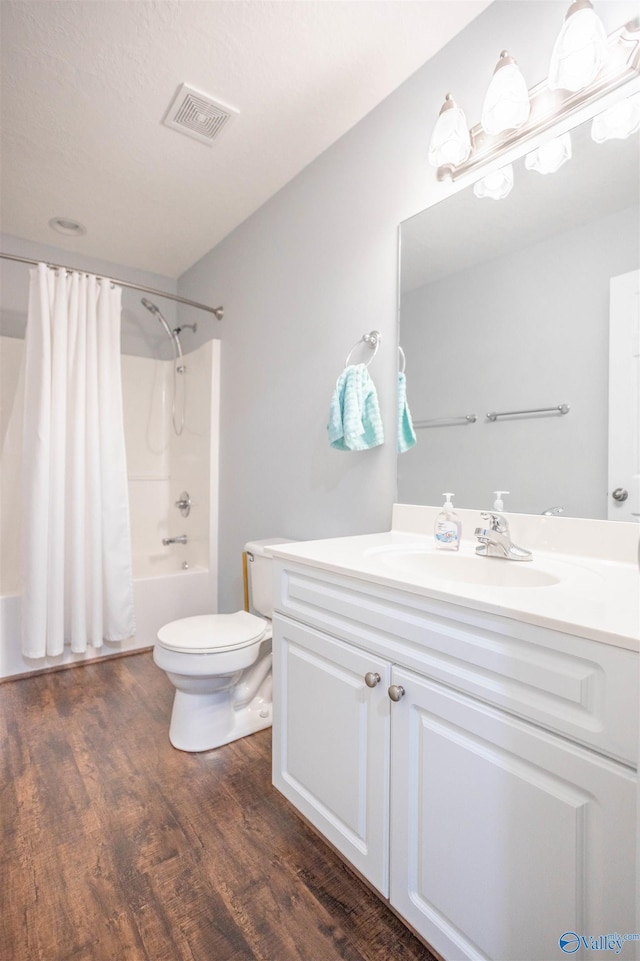 full bathroom with wood-type flooring, toilet, vanity, and shower / bath combo