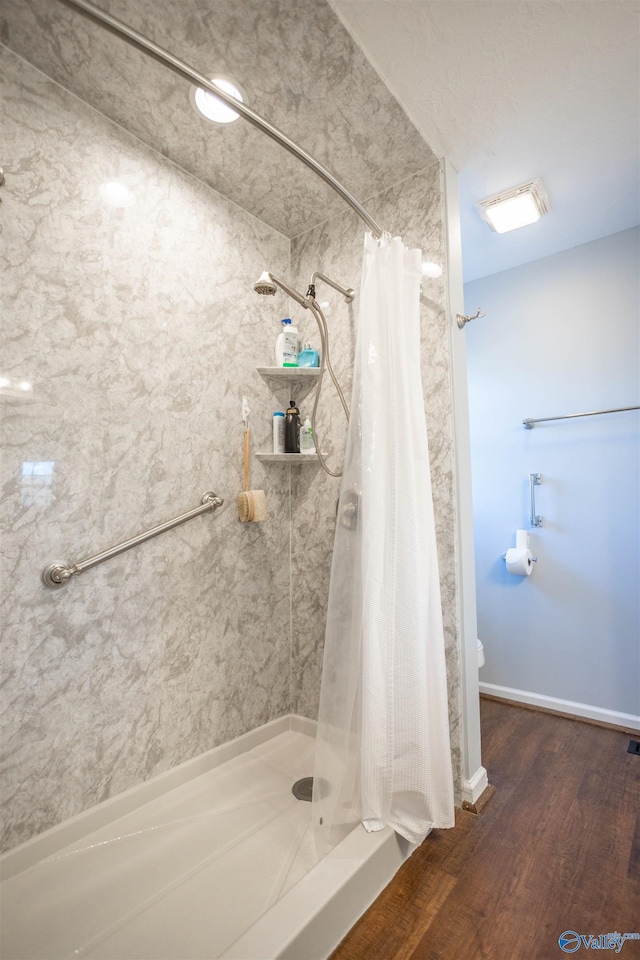 bathroom featuring walk in shower and hardwood / wood-style floors