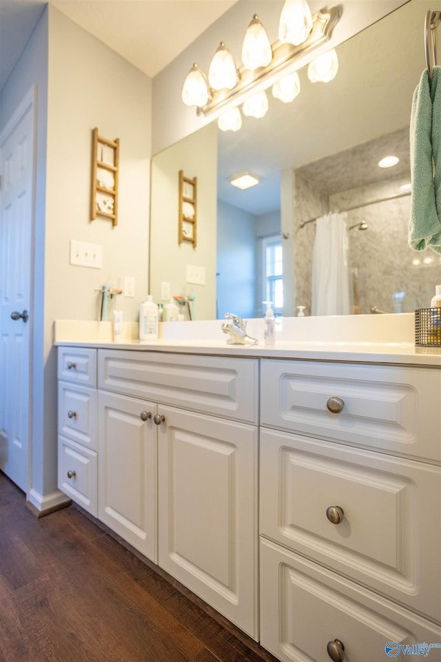 bathroom featuring walk in shower, vanity, and hardwood / wood-style floors