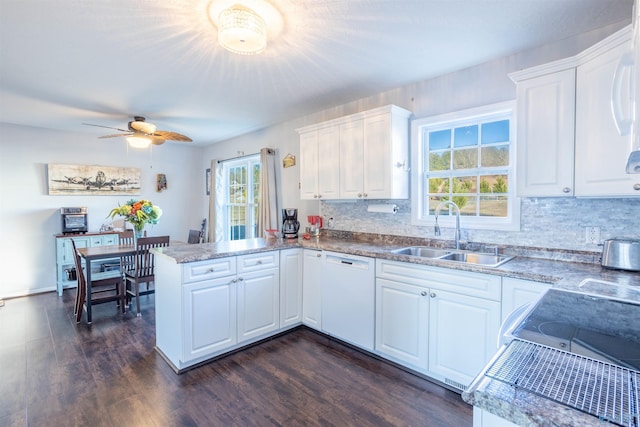 kitchen featuring dark hardwood / wood-style floors, white cabinetry, dishwasher, sink, and kitchen peninsula