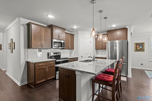 kitchen with appliances with stainless steel finishes, a sink, baseboards, crown molding, and tasteful backsplash