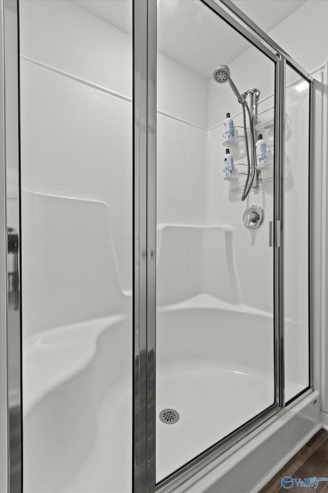 full bathroom with a shower stall and wood finished floors