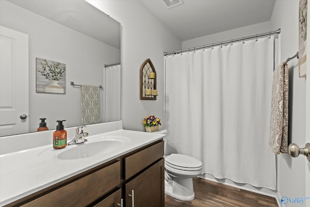 full bath featuring wood finished floors, toilet, vanity, and shower / tub combo with curtain