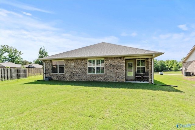 rear view of property featuring central air condition unit and brick siding