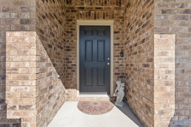 view of exterior entry with brick siding