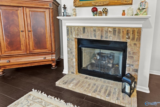detailed view of a fireplace, baseboards, and wood finished floors