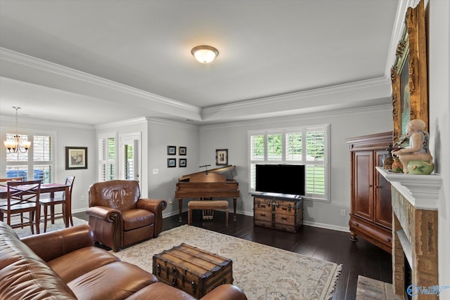 living room with a chandelier, dark wood-style flooring, a tray ceiling, baseboards, and crown molding